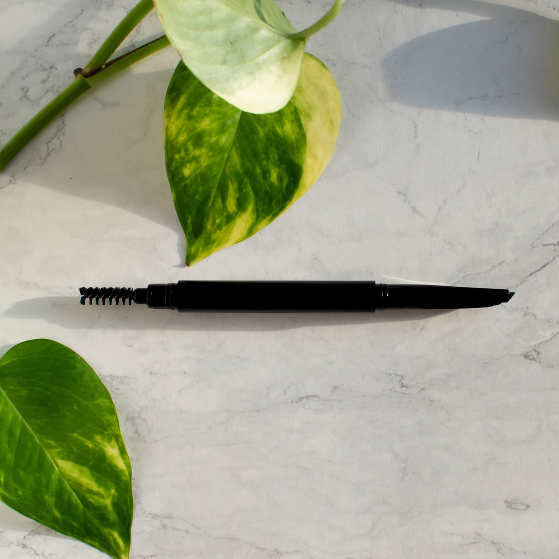 The sleek dual-ended exterior barrel design of the Cruisin Organics Black Automatic Eyebrow Pencil highlighting its modern, minimalist branding.