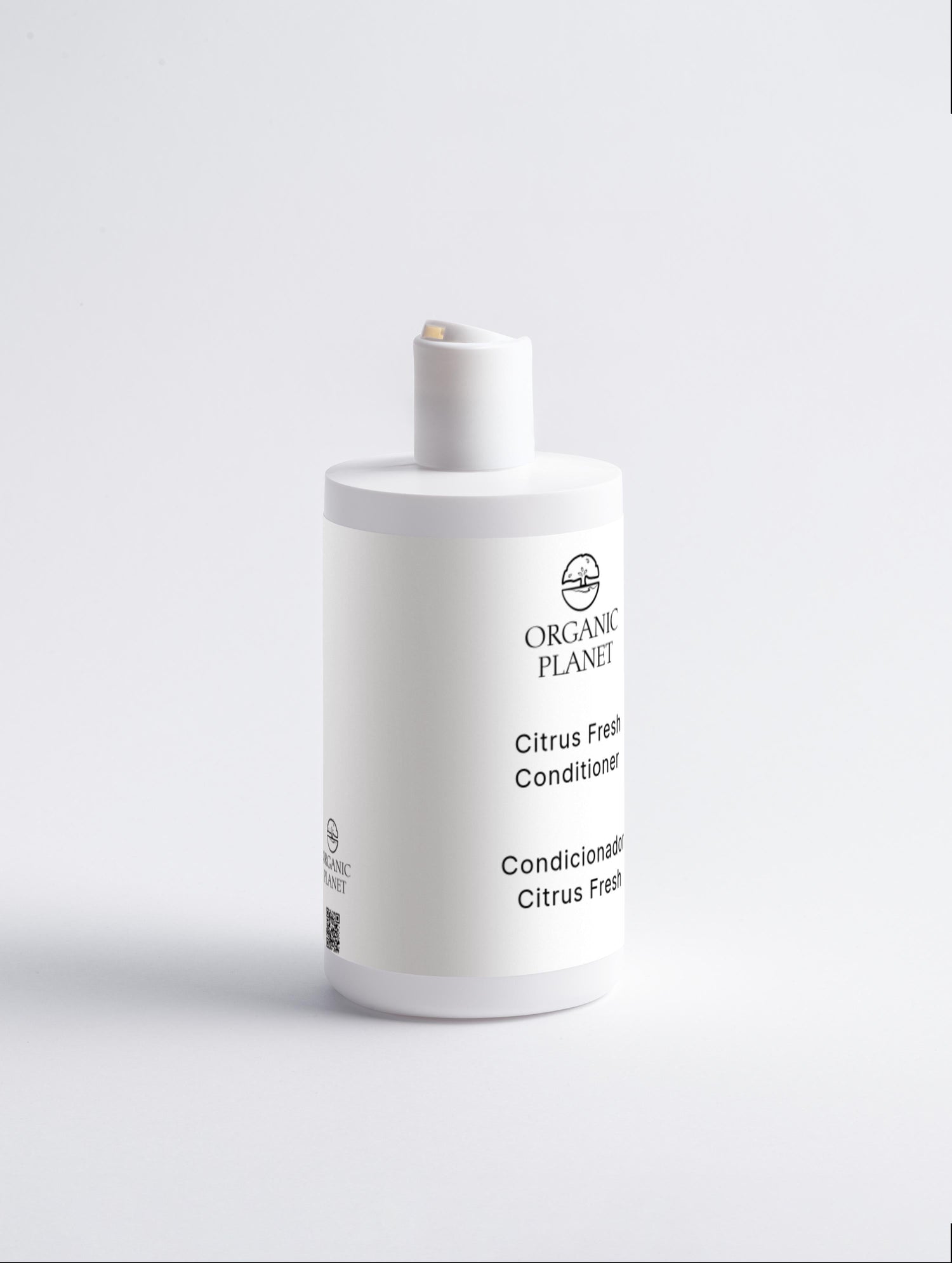 White bottle of Organic Planet Citrus Fresh Conditioner on a light gray background. This conditioner nourishes and protects hair ends, reducing breakage and split ends. It helps hair feel silky, adds volume, and makes styling easier. Suitable for all hair types, it features a refreshing Citrus Cocktail.